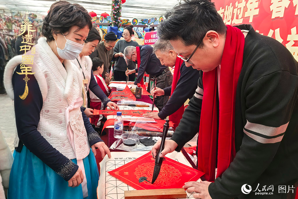 新春佳節(jié)之際，長春農(nóng)博園冬季展會(huì)火熱進(jìn)行，展廳內(nèi)，書法家現(xiàn)場書寫“?！弊?，市民游客紛紛上前迎春接“?！?。人民網(wǎng)記者 王海躍攝